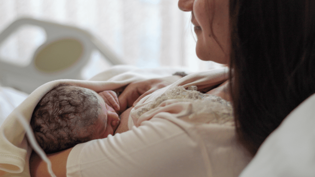 Newborn breastfeeding, mother in biological nurturing reclined position in bed